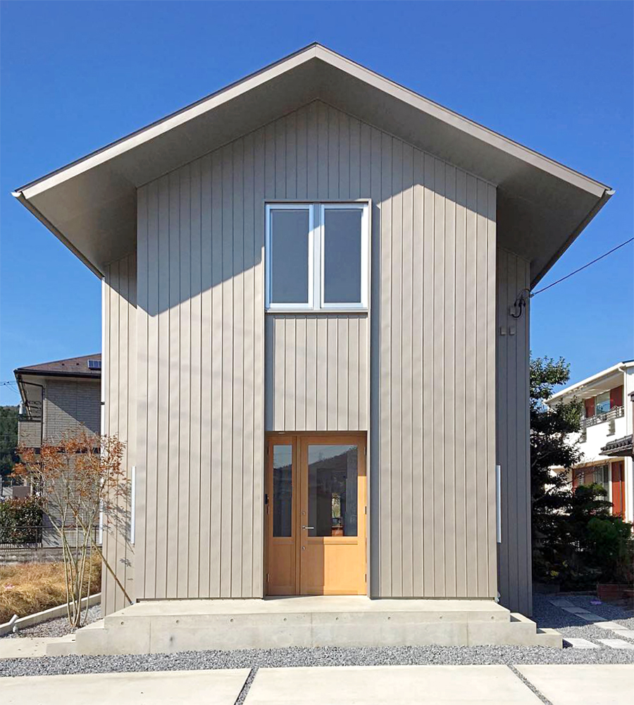 建物東面の外観風景。中央に木材建具で作られた玄関がある。