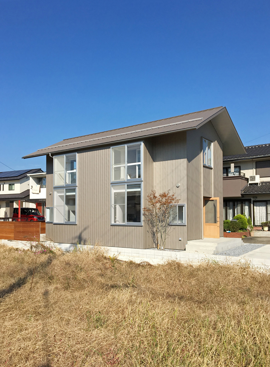 建物南東面の外観風景。外壁はベージュ色のガルバリウム鋼板が貼られている。