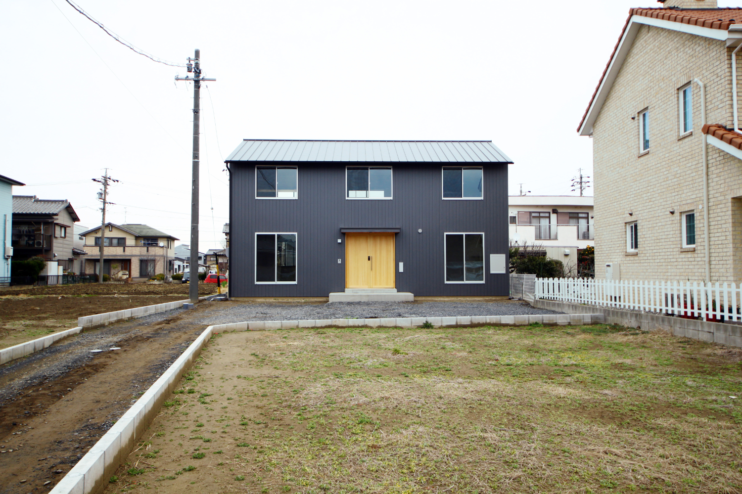 建物南面の外観。旗竿敷地に建つ住宅の風景。