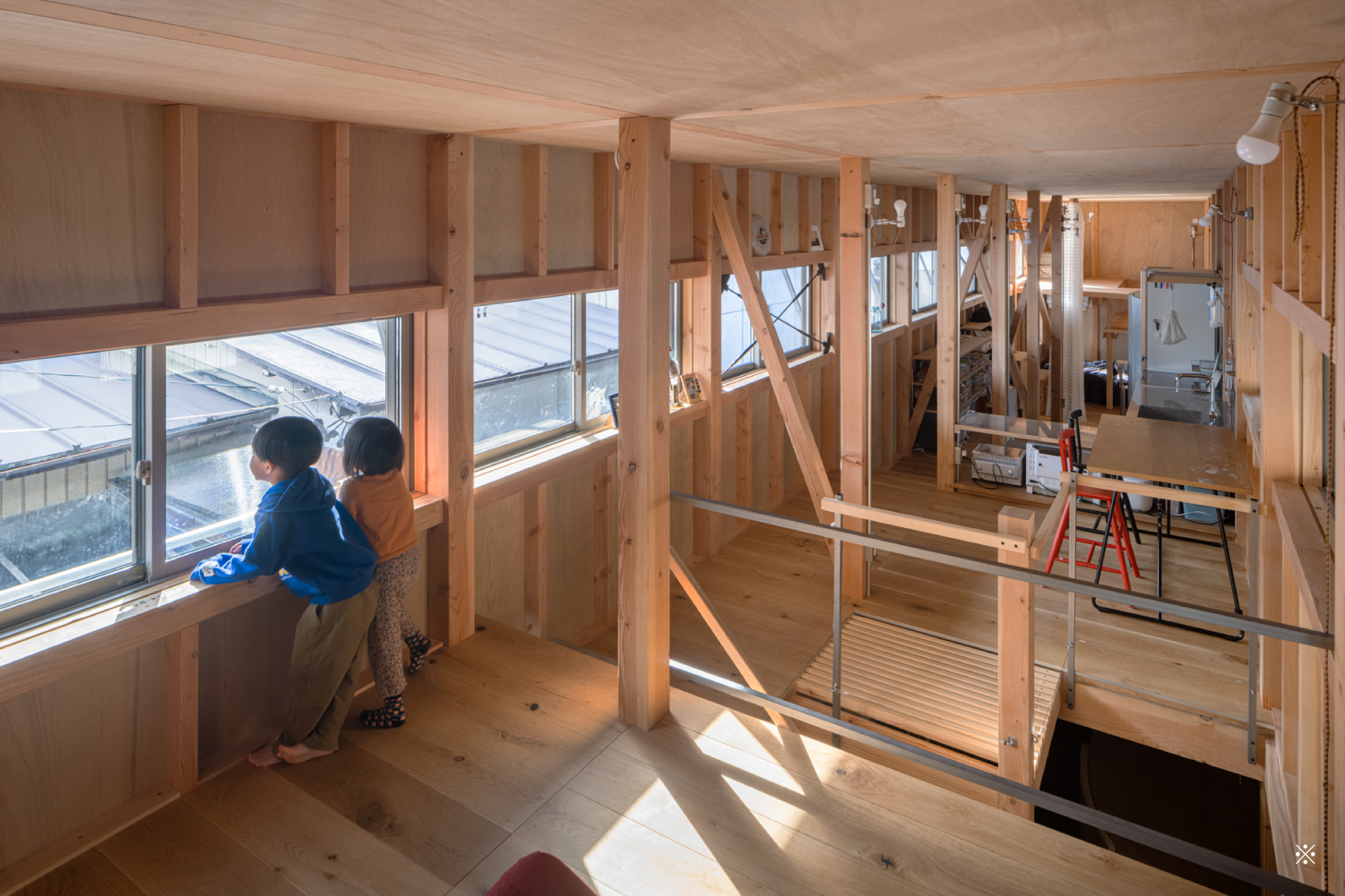 ２階室内のリビング風景02。子どもが２人窓辺で外の風景を眺めている。