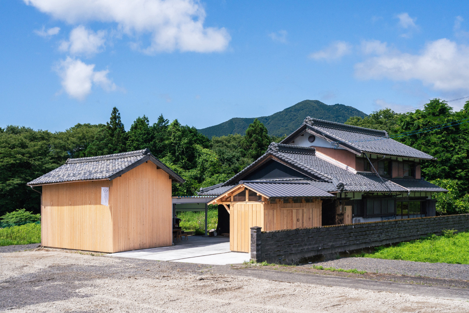 建物全体の外観。周りは、木々や山に囲まれている。